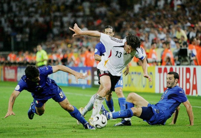 Michael Ballack lao về phía trước bất chấp sự truy cản của Gennaro Gattuso (trái) và Gianluca Zambrotta (phải) trong trận bán kết Đức – Italia tại World Cup 2006.